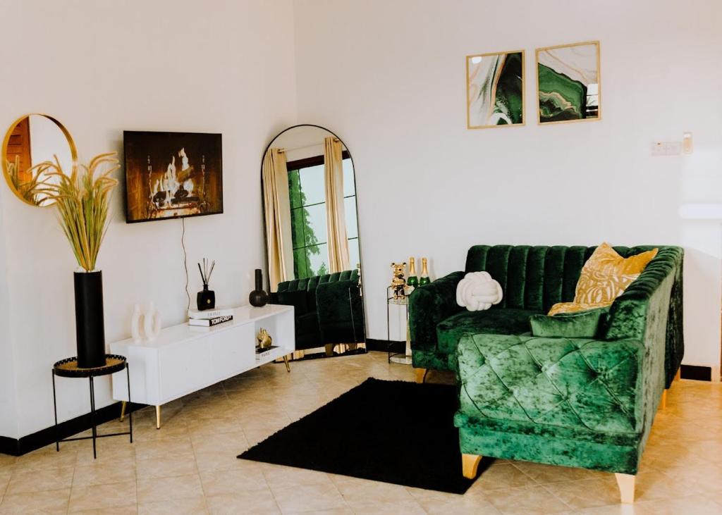 een woonkamer met een groene bank en een spiegel bij LM Apartments in Dar es Salaam