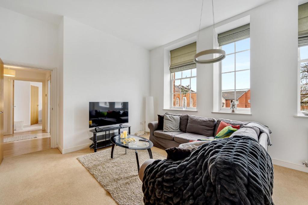 ein Wohnzimmer mit einem Sofa und einem TV in der Unterkunft Pass the Keys Luxury 2 Apt in West Didsbury in Manchester