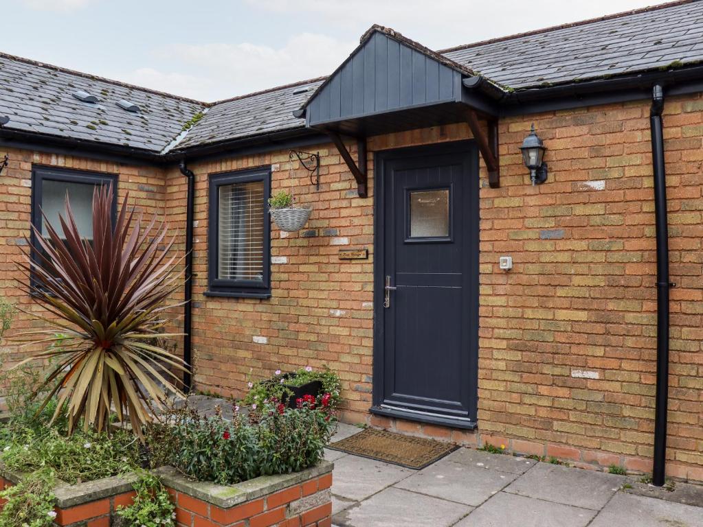 a brick house with a black door at Fern Cottage in Cardiff