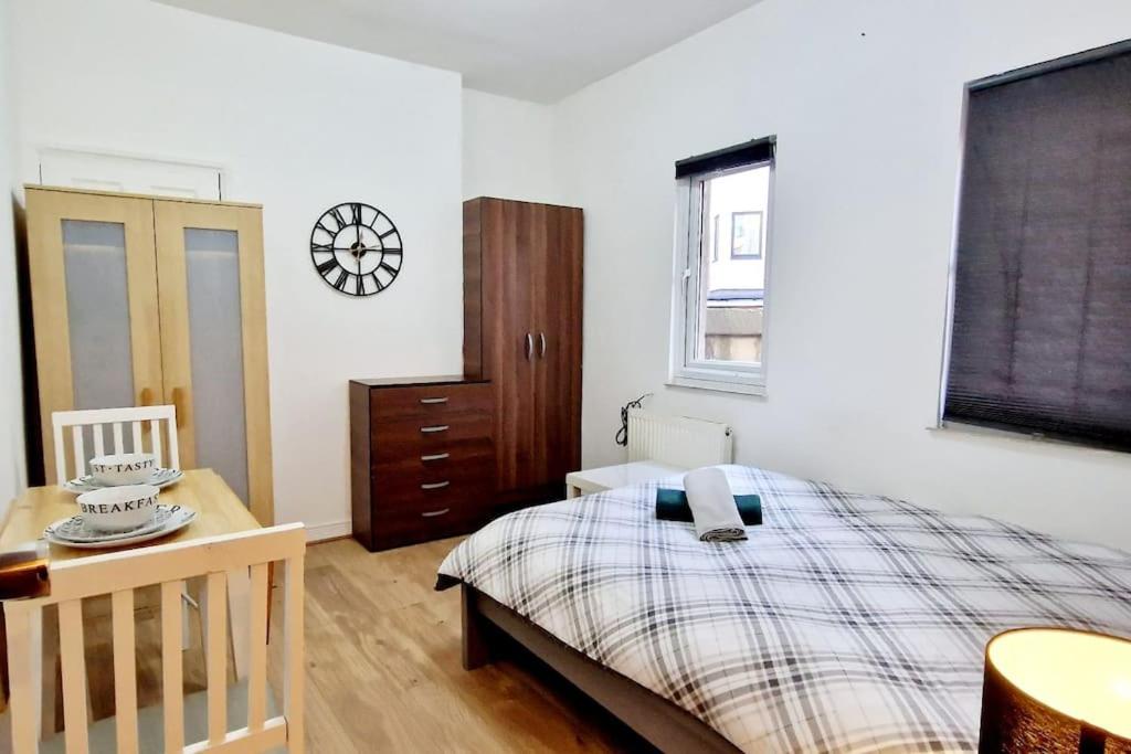 a bedroom with a bed and a desk and a window at Lovely Studio- Aldgate East Stn in London