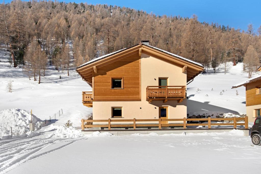 eine Blockhütte im Schnee mit Bäumen in der Unterkunft Palipert Nature House in Livigno