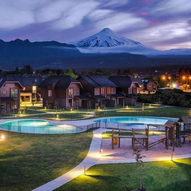 a resort with a snow covered mountain in the background at Bella casa en Costa Pucón in Pucón