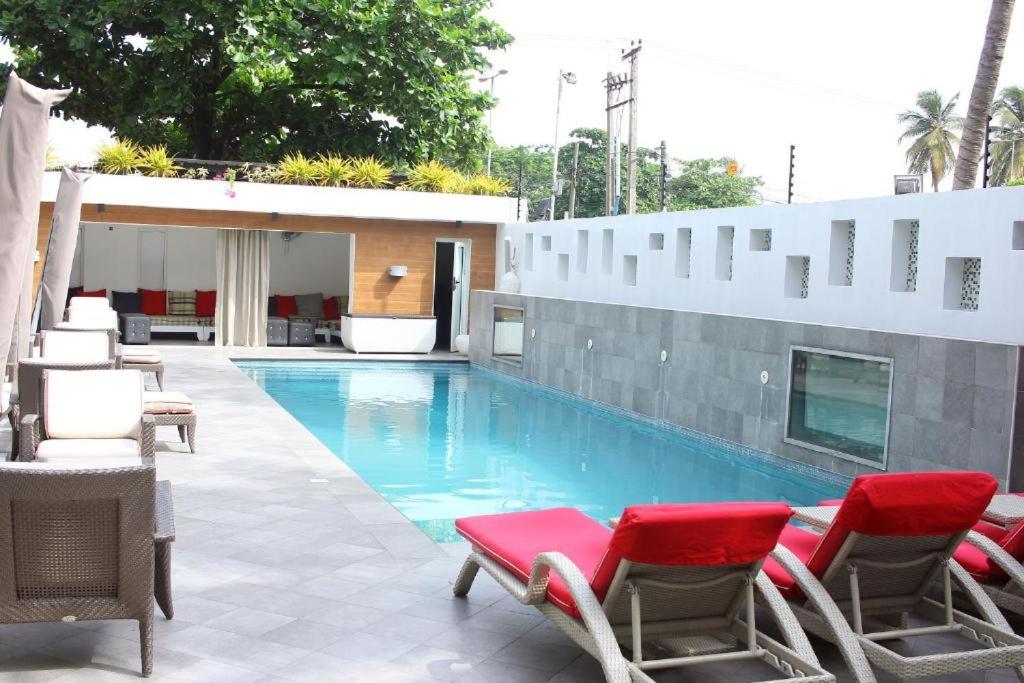 a swimming pool with lounge chairs and a swimming pool at eTraver Hospitality in Ikeja
