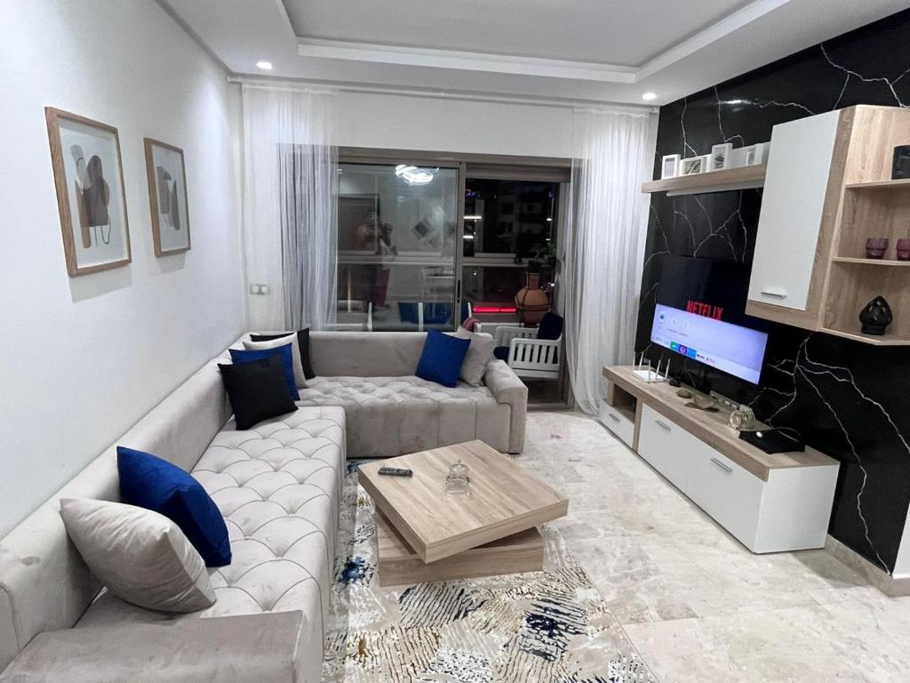 a living room with a couch and a tv at Superbe Appartement Meublé in Mohammedia