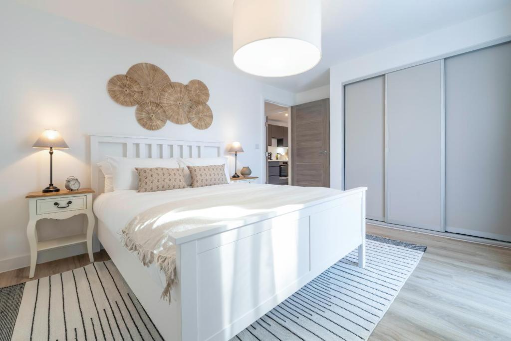 a white bedroom with a large white bed and a window at Tranquil Retreats in the Scenic Cotswolds in Stroud