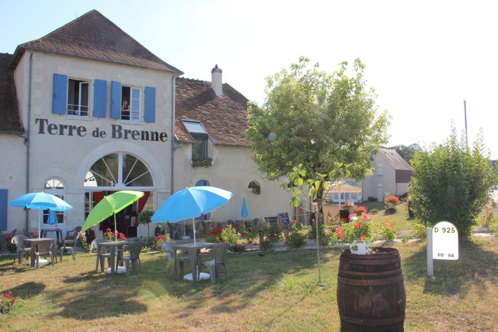 budynek ze stołami i parasolami przed nim w obiekcie Terre de Brenne w mieście Azay-le-Ferron