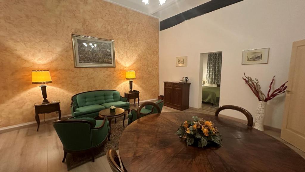 a living room with a table and green chairs at Hotel Roma in Bologna
