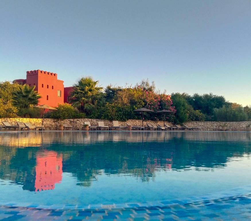 a large body of water with a building in the background at Domaine de l'Arganeraie Essaouira in Essaouira