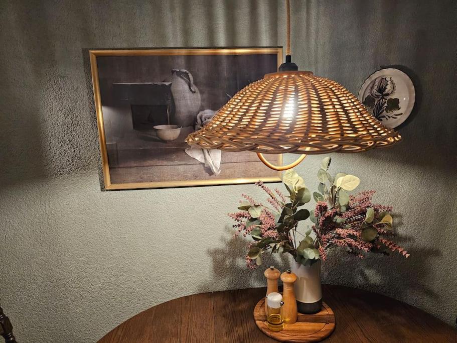 a lamp on a table with a picture and flowers at Friends&Family Veldenz L in Veldenz