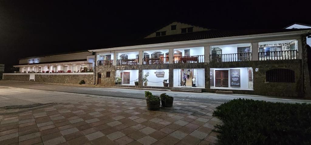un gran edificio con luces encendidas por la noche en Hosteria Iloca, en Iloca