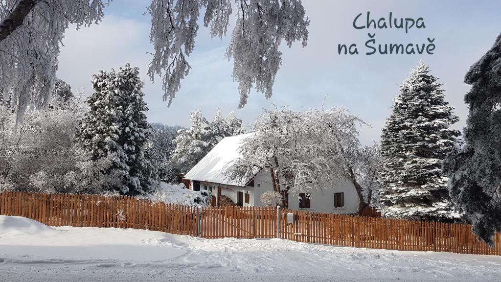 una casa cubierta de nieve junto a una valla en Chalupa na Šumavě, od soboty do soboty en Nová Ves