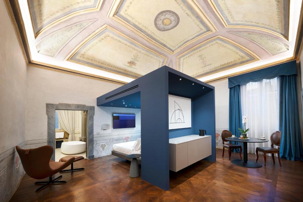 una camera da letto con soffitto a cassettoni, letto e tavolo di Palazzo Giusti Suites and Spa a Urbino