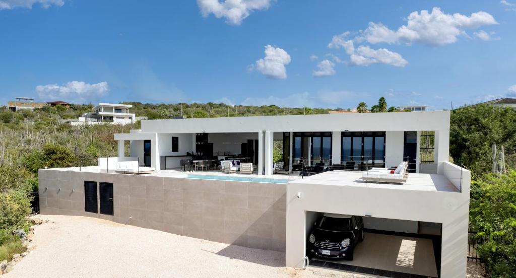 a large white house with a swimming pool at Villa Regatta in Kralendijk