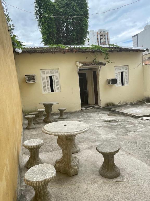 um grupo de mesas e bancos em frente a um edifício em Status Casa Pelinca em Campos dos Goytacazes