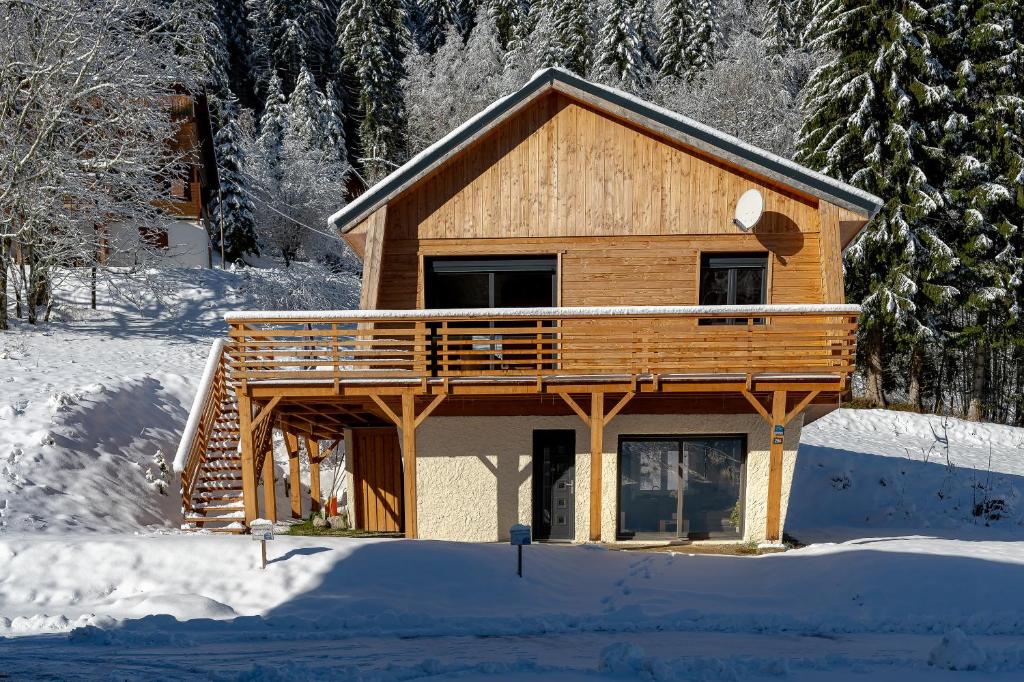 a log cabin in the snow with snow covered trees at Chalet les Iris in Le Massot