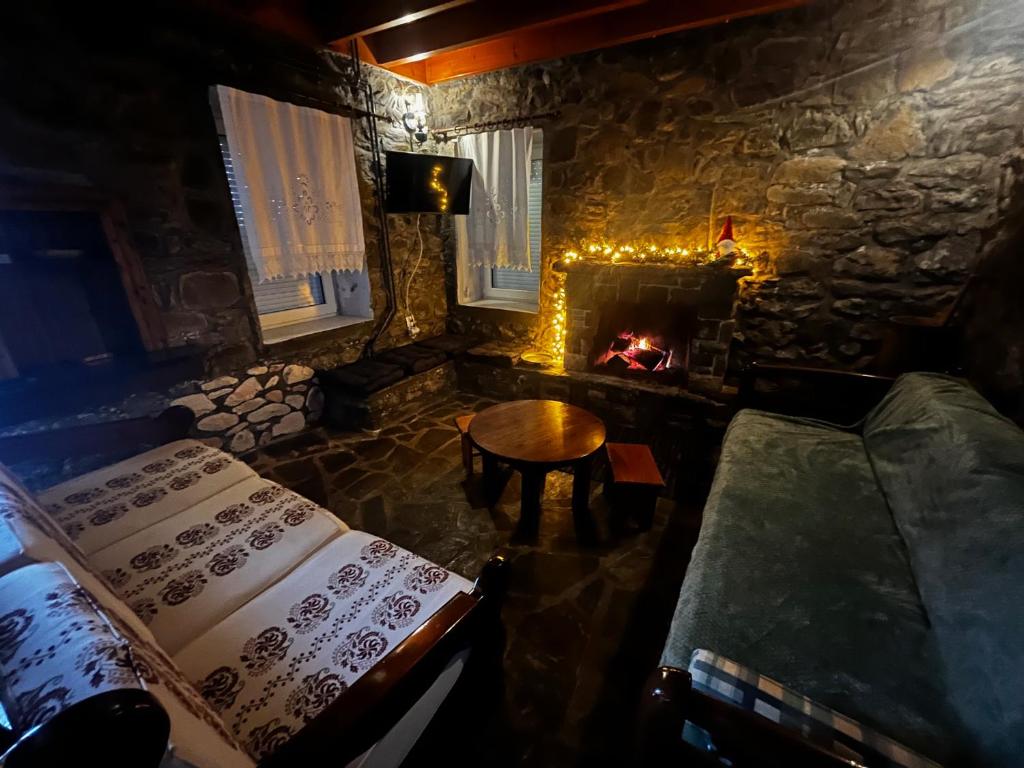 a room with a fireplace and a table and a couch at Chalet Karpenisi in Karpenision