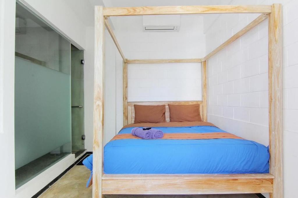 a bed with a wooden frame in a room at NeoMoritz Homestay in Bandung