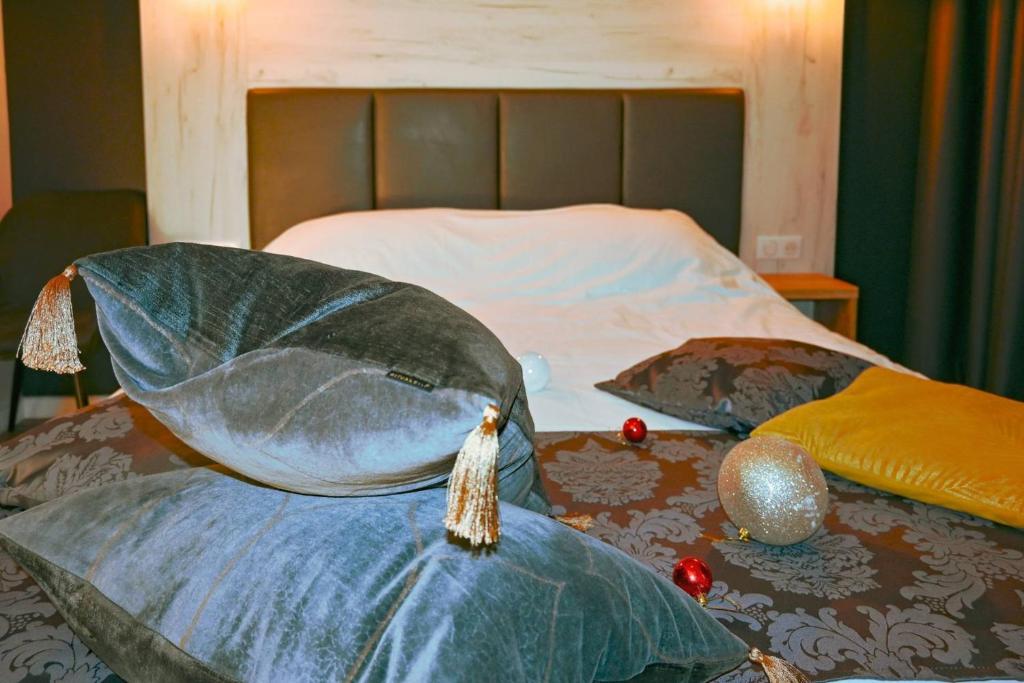a bed with two pillows on top of it at Logis Clermotel - Hôtel & Restaurant in Agnetz