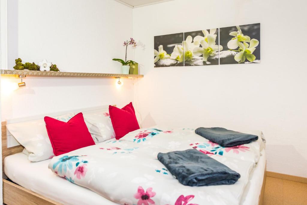 ein Bett mit roten und weißen Kissen darauf in der Unterkunft Ferienwohnung Naturpur in Rheinau