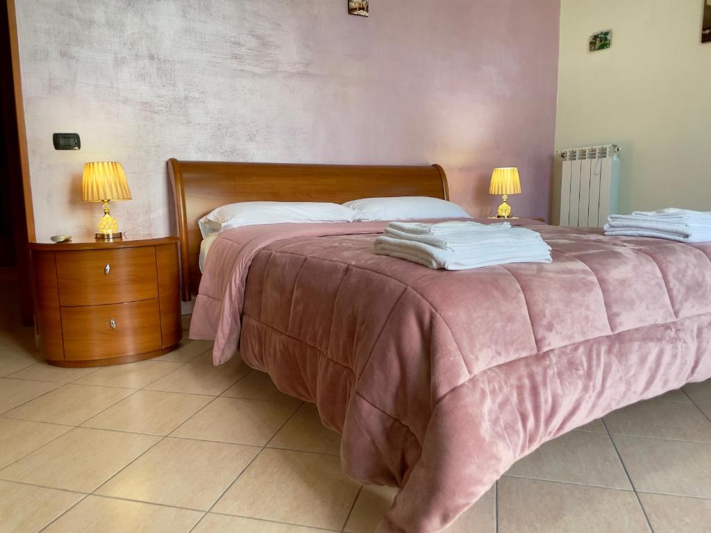 - une chambre avec un lit avec une couverture rose et 2 lampes dans l'établissement Free WI-FI- Vista mare e Vesuvio-Casa Laura, à Naples