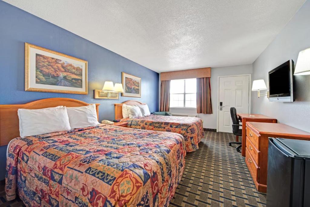 a hotel room with two beds and a desk at Day Star Dallas in Dallas