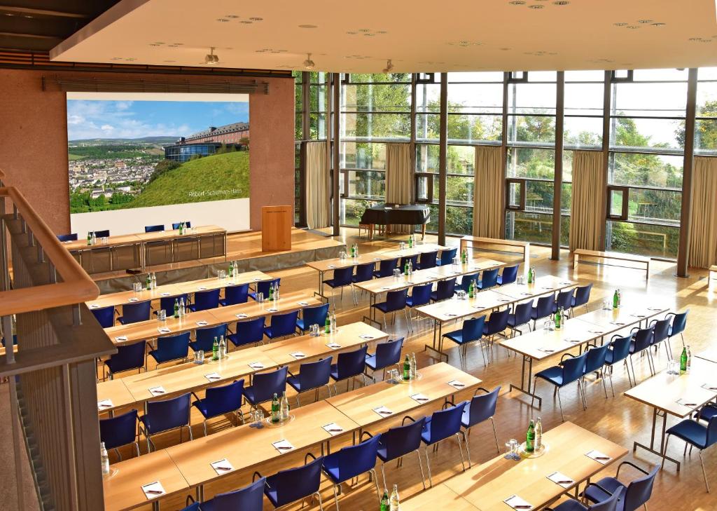 a large dining room with tables and blue chairs at Robert-Schuman-Haus in Trier