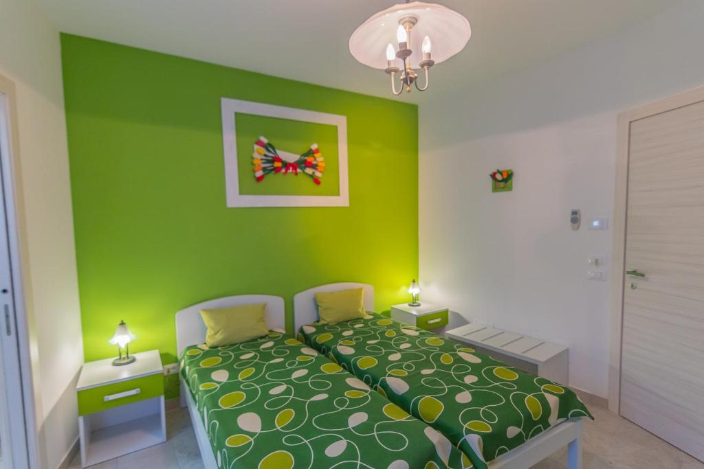 a green bedroom with a bed and a green wall at B&B Tulip Lotus Castelbuono in Castelbuono