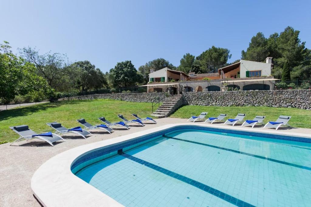 einen Pool mit Liegestühlen und ein Haus in der Unterkunft Es Puig de Ses Coves in Santa Eugènia