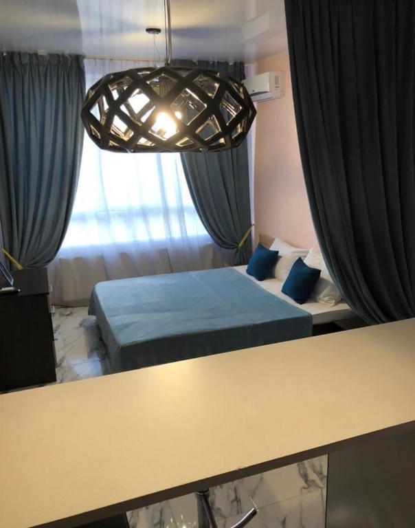 Zimmer mit einem Bett und einem Tisch mit Vorhängen in der Unterkunft VIP apart 525 in Tbilisi City