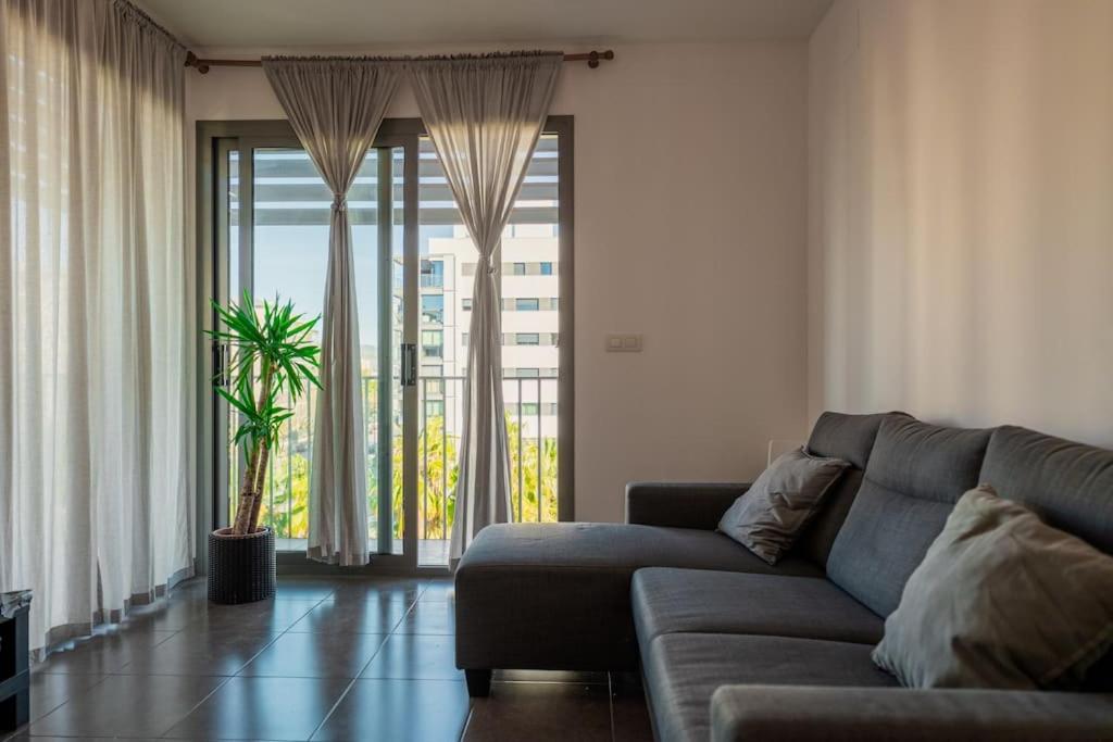 - un salon avec un canapé et une grande fenêtre dans l'établissement Chic City Haven: Modern Apartment in Castellón, Castellón de la Plana