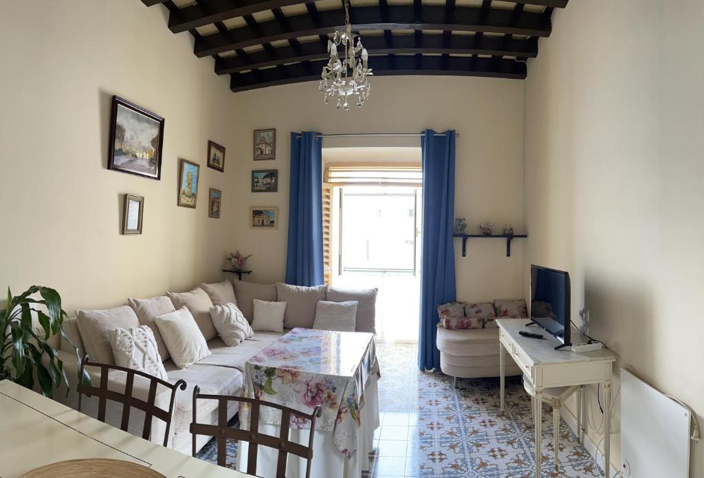 sala de estar con sofá y mesa en Casa Lola, en El Puerto de Santa María