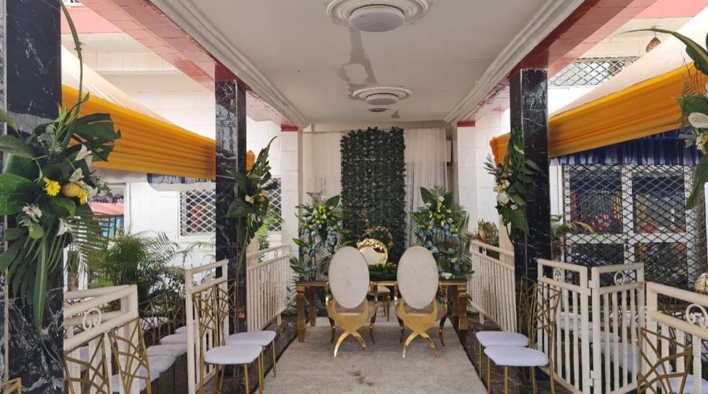 einen Tisch und Stühle in einem Zimmer mit Pflanzen in der Unterkunft Hôtel appartement luxe in Foumban