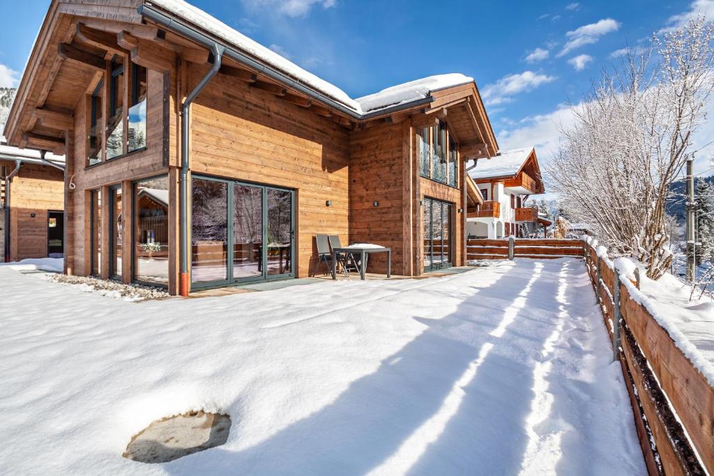 a log home in the snow with a patio at Chalet Aus Holz in Garmisch-Partenkirchen