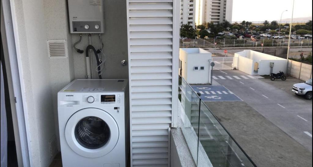 lavadora situada en un lateral de un balcón en Departamento cercano a la playa en La Serena