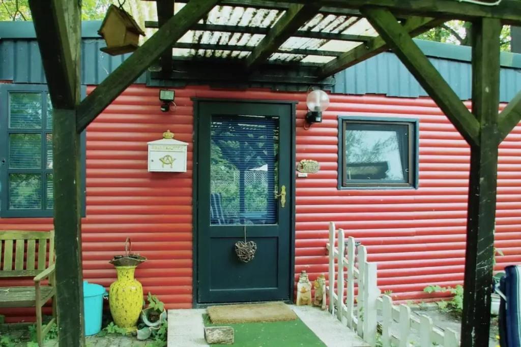 een rood huis met een groene deur bij Piraten Nest in Schortens