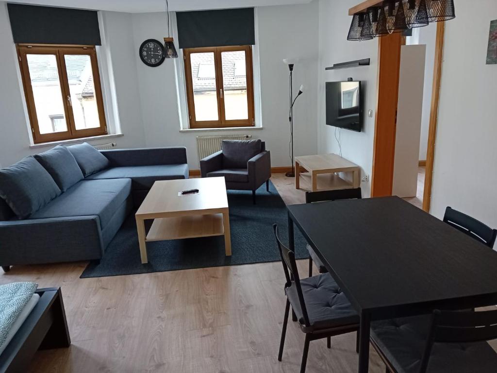 sala de estar con sofá azul y mesa en Zentral und ruhig in Auerbach, en Auerbach