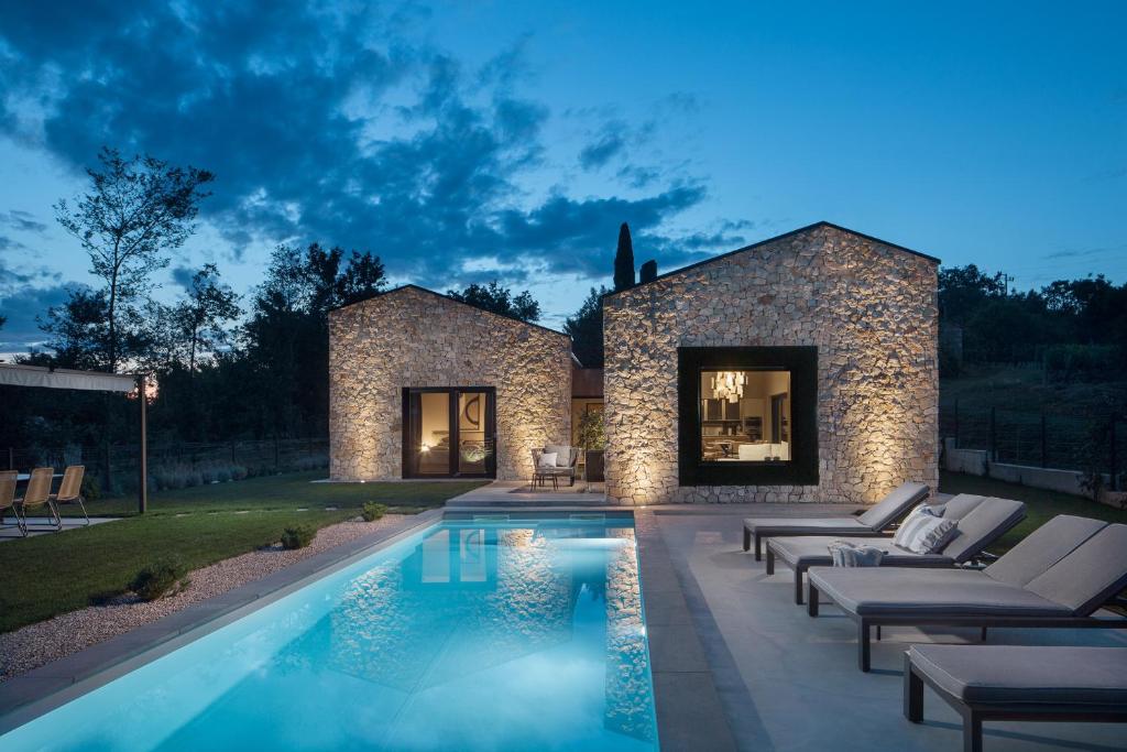 a swimming pool in the backyard of a house at Villa Ulmus near Motovun for 6 people with heated pool & jacuzzi in Karojba