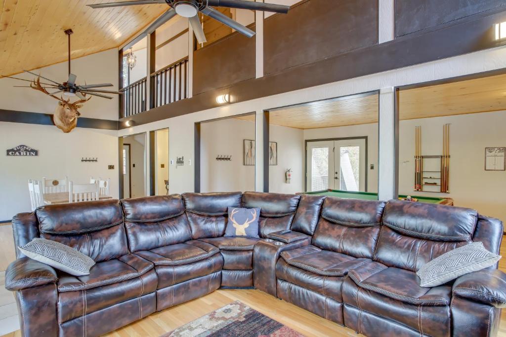 a large leather couch in a living room with a table at Ruidoso Cabin Retreat with Multi-Level Deck in Ruidoso