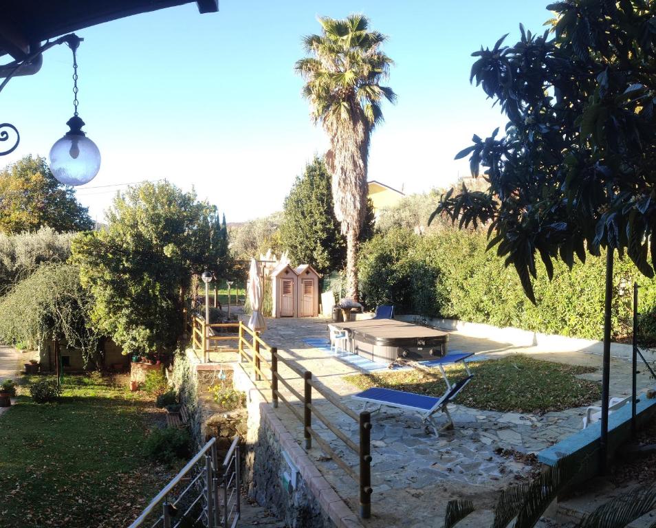 einen Hinterhof mit einem Tisch und einer Palme in der Unterkunft La Liguria tra gli Ulivi 2 in Varraze