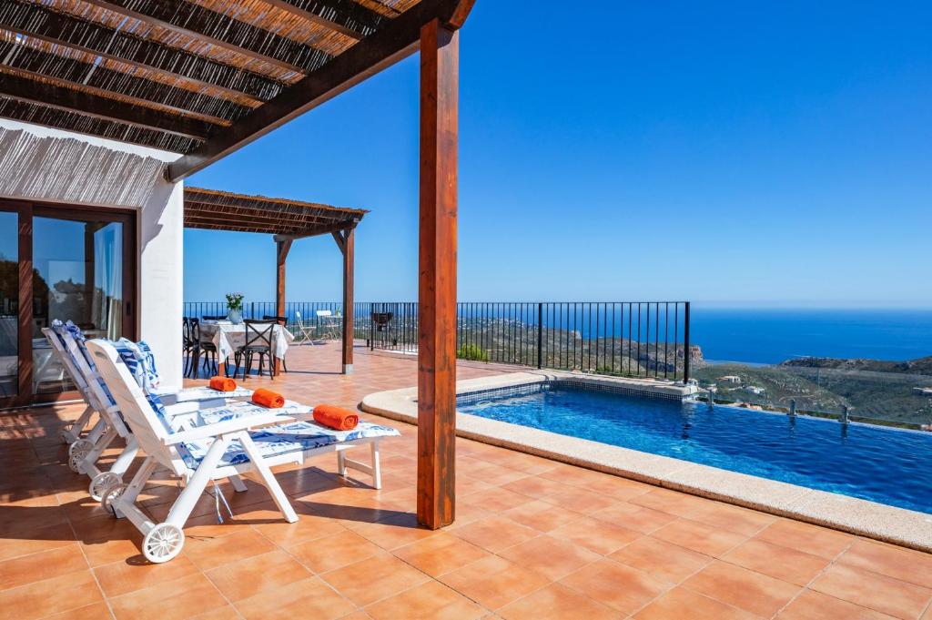 a villa with a swimming pool and a patio at Villa Amanecer by Villa Plus in Cumbre del Sol