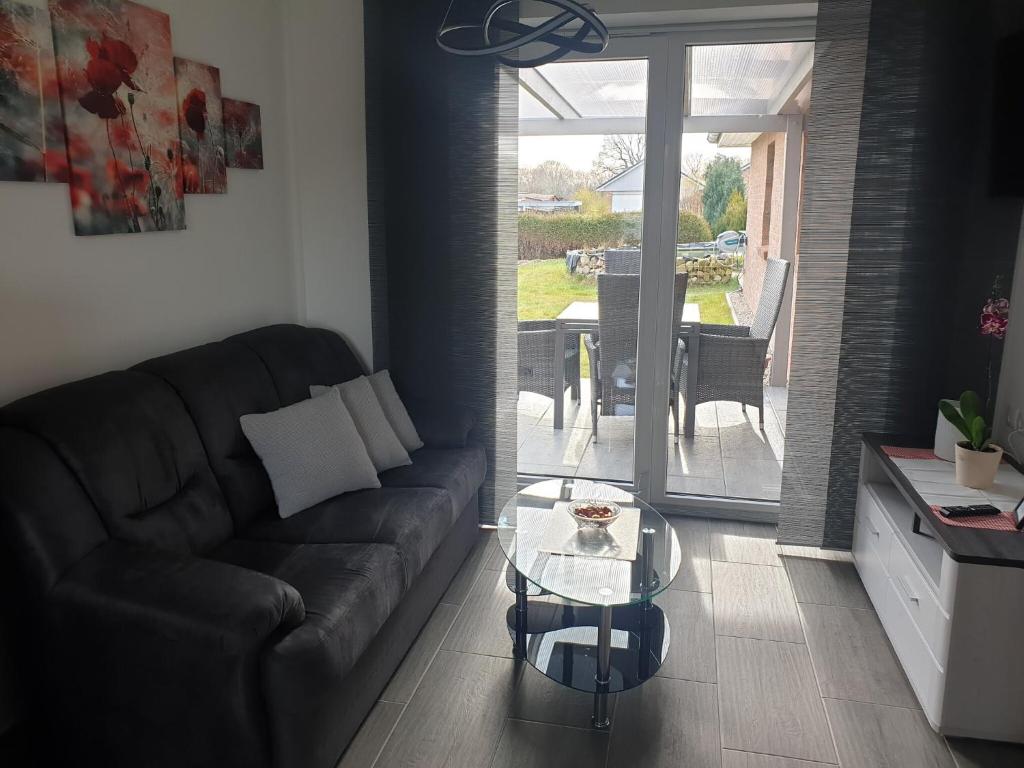 a living room with a couch and a glass table at Ferienwohnung Völkner in Hamdorf