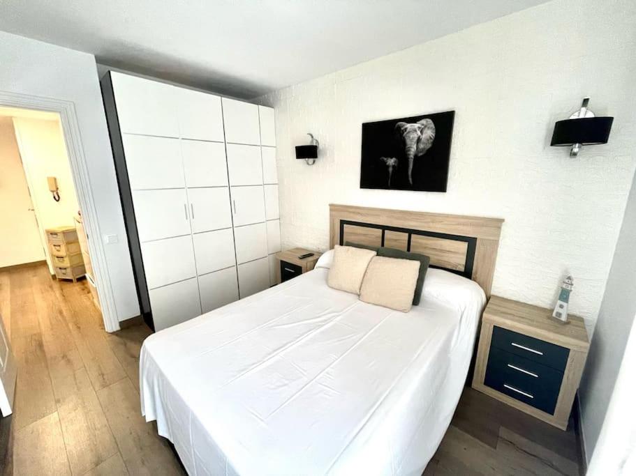 a bedroom with a white bed in a room at SeaHomes Vacations - CORAL SUN in Fenals Beach in Lloret de Mar