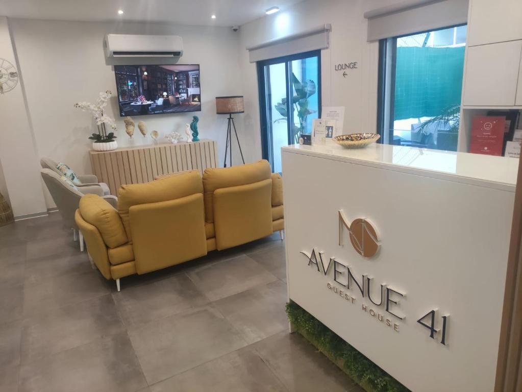 a waiting room with two yellow chairs and a counter at Avenue 41 Guest House in Faro