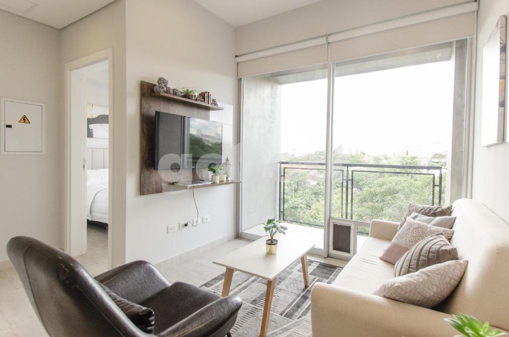 ein Wohnzimmer mit einem weißen Sofa und Stühlen in der Unterkunft Exquisite And Comfortable Villa Morra Apartment in Asunción
