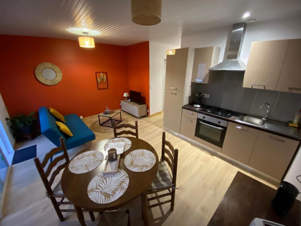 a kitchen and dining room with a table and chairs at Le cosy in Labarde