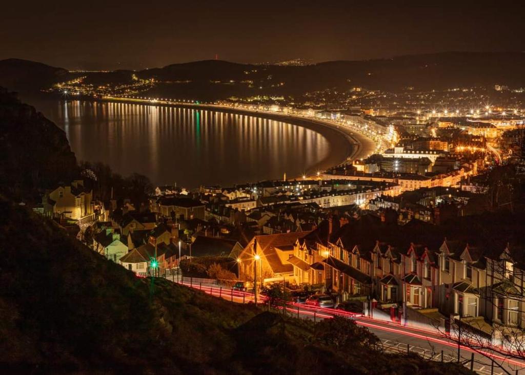 a view of a city at night with a river and houses at Iris Hotel Llandudno in Llandudno