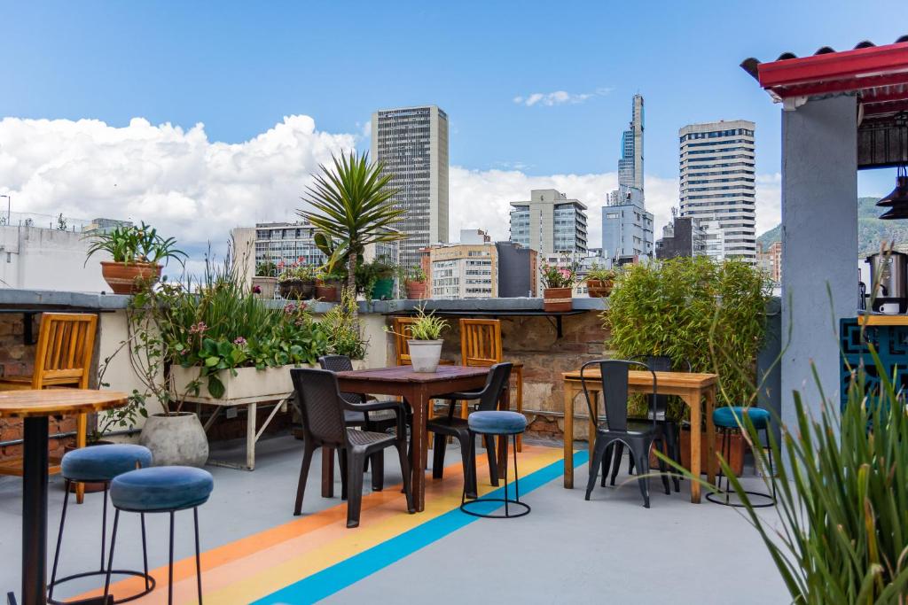 a patio with tables and chairs and a city skyline at Hostal R10 in Bogotá