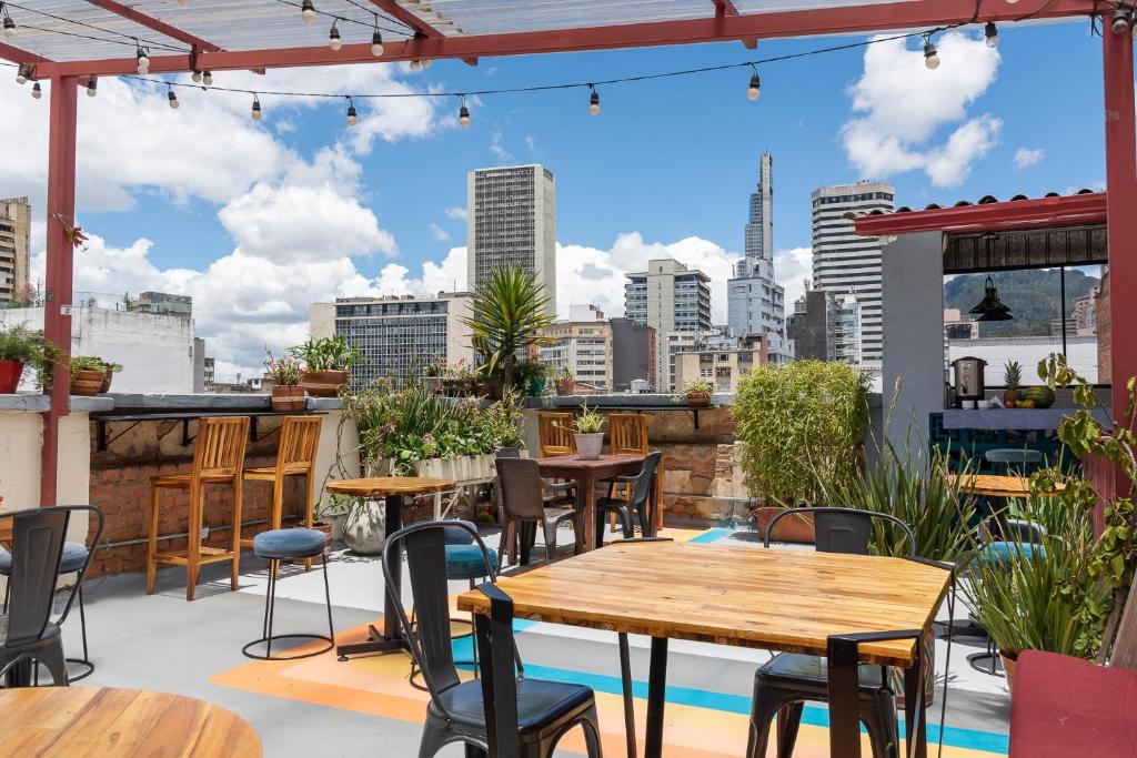 a patio with tables and chairs and a view of the city at Hostal R10 in Bogotá