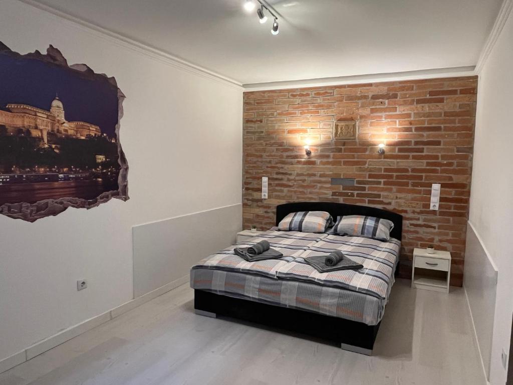 een bed in een kamer met een bakstenen muur bij Fancy home Budapest in Boedapest