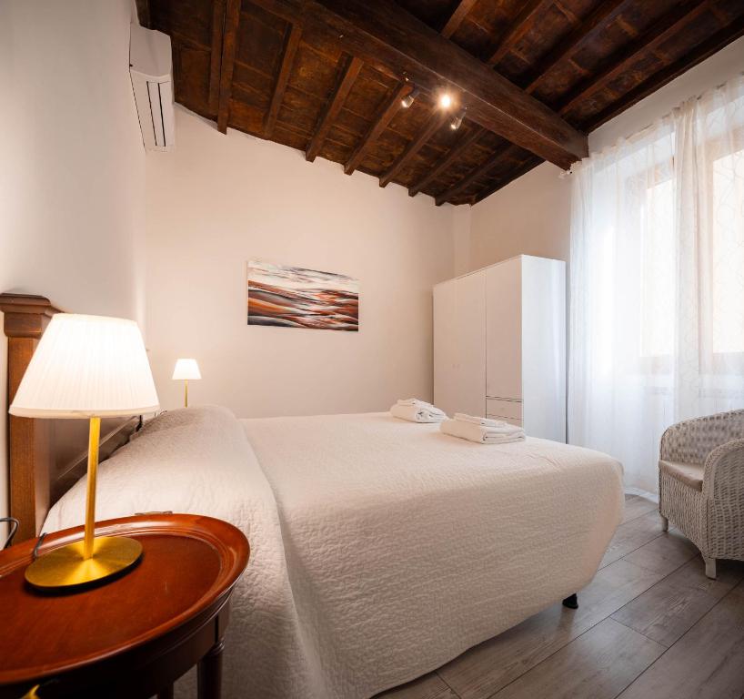 um quarto com uma cama e uma mesa com um abajur em Art Novella Gallery em Florença